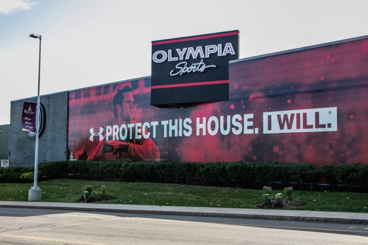 Olympia Sports store with an under armour slogan displayed on the side of the building. "Protect this house. I will.